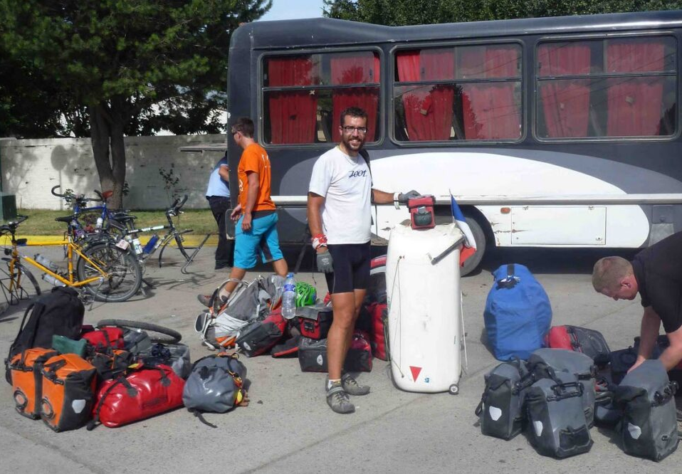 Remorque dressée sur ses roulettes devant un autocar parmi les bagages