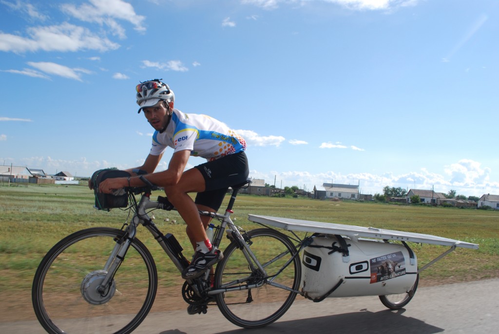 Cycliste roulant avec une remorque portant un panneau solaire